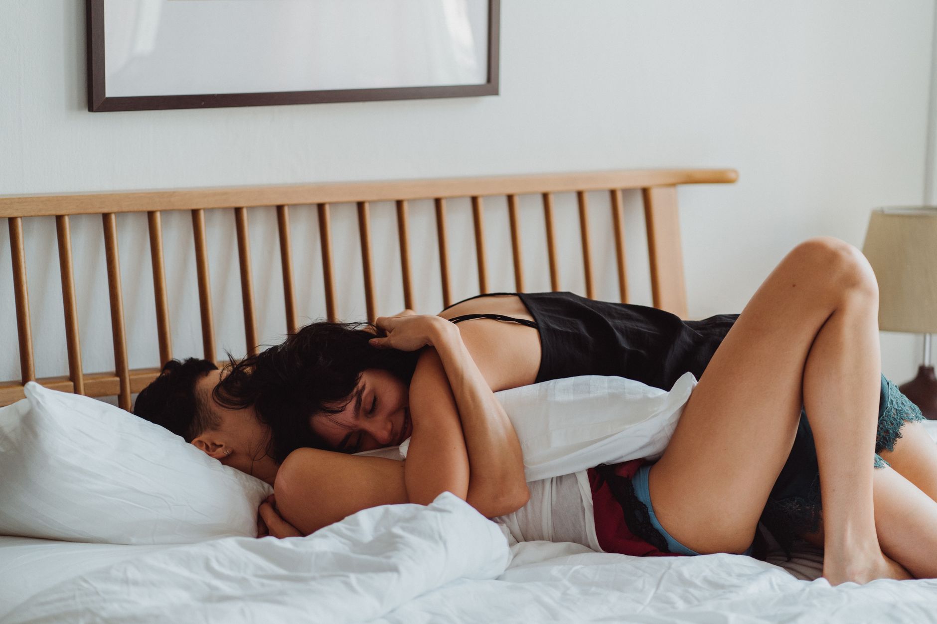A loving couple embracing on a bed, showcasing warmth and intimacy in a cozy indoor setting.