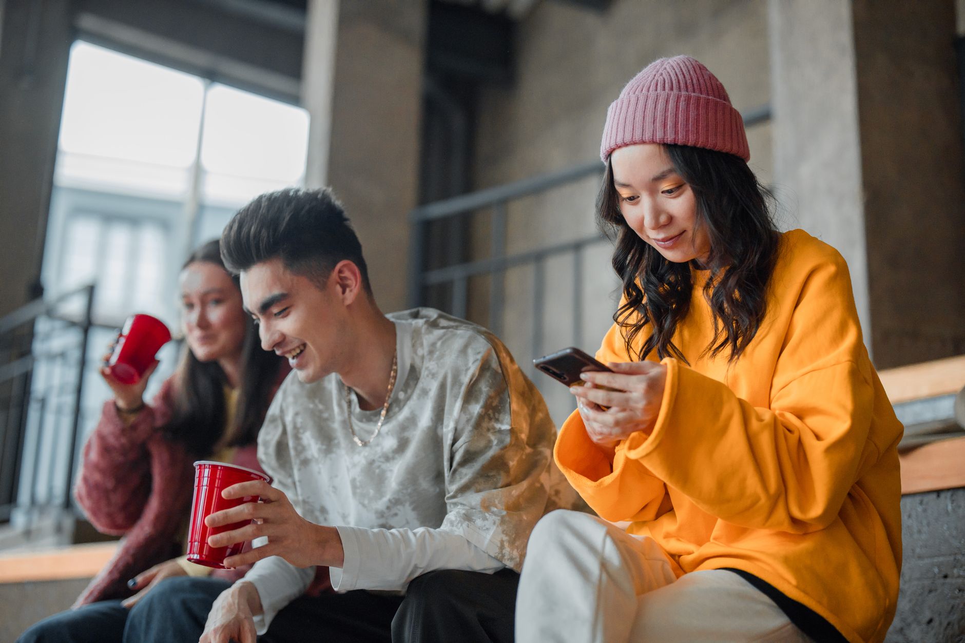 Young adults enjoying a casual hangout indoors, capturing moments and sharing laughter.