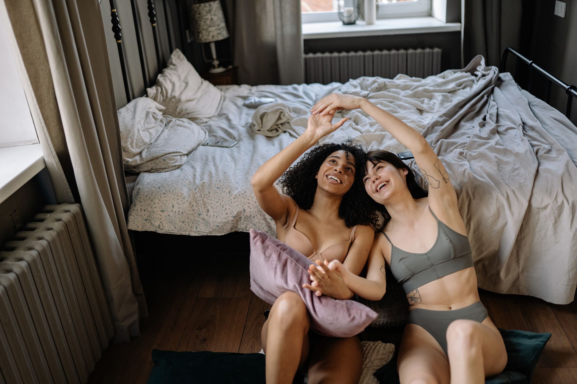 A happy couple enjoying a moment together in a cozy bedroom setting, capturing love and relaxation.